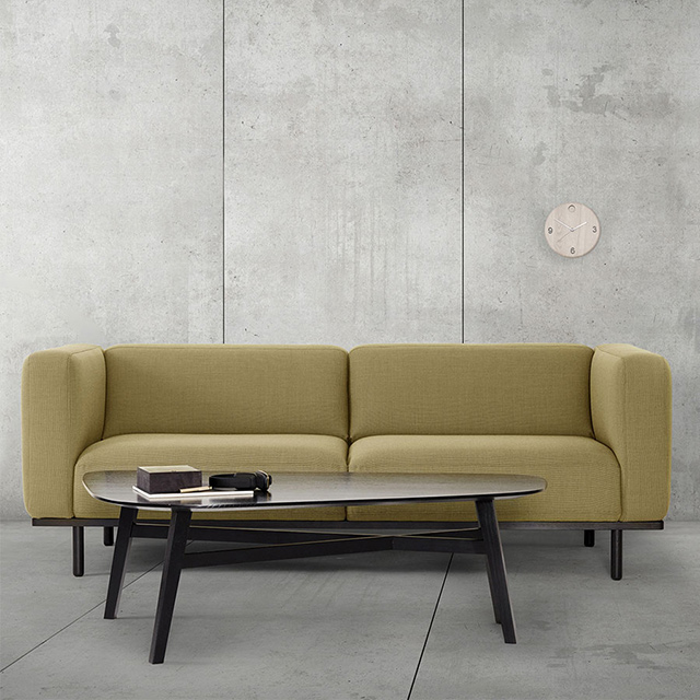 Andersen Furniture A1 Sofa als 3-Sitzer mit beigefarbenem Stoffbezug Breeze Fusion 4801 und dunklem Holzgestell, kombiniert mit einem schwarzen Couchtisch.