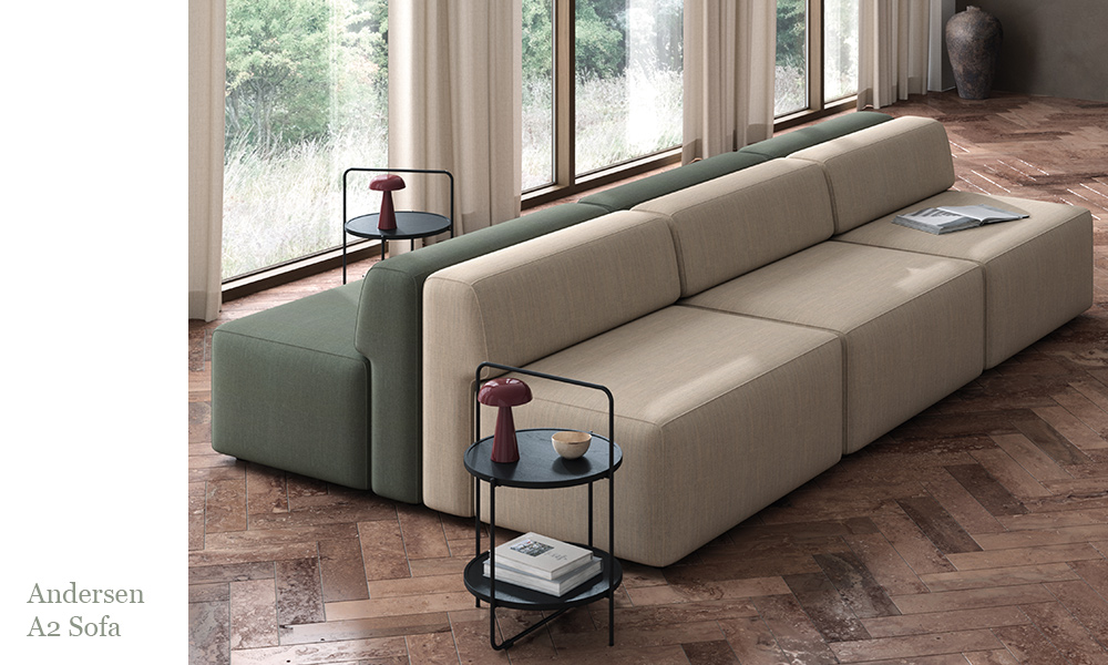 Andersen Furniture A2 Sofa als modulares Sofa mit beigefarbenem und grünem Kvadrat Fiord Stoff, inszeniert in einem modernen Wohnraum mit großen Fenstern.