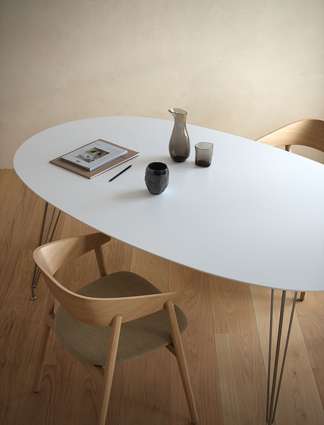 Andersen Furniture DK10 Esstisch mit heller Tischplatte aus Alpino-Laminat und filigranen verchromten Tischbeinen, kombiniert mit Eichenholzstühlen.