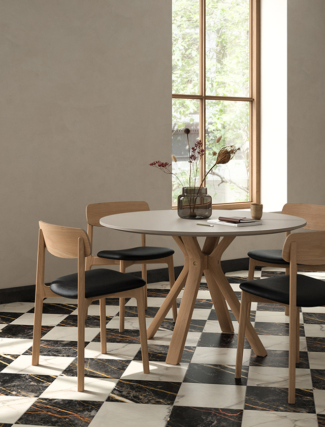 Andersen Furniture Space Round Table mit Tischplatte in Beige Arizona und ANCH Chairs aus Eiche mit schwarzem Sitzpolster.