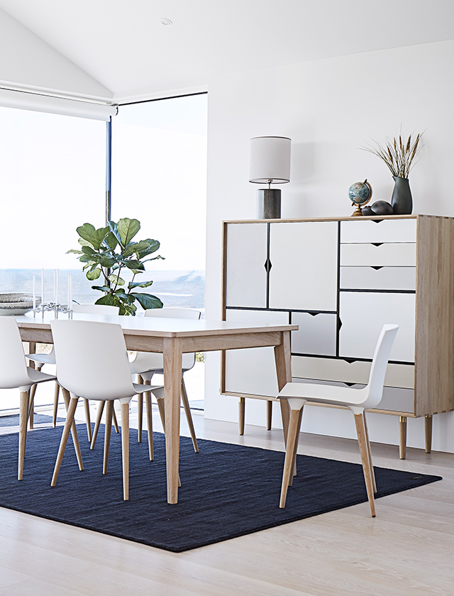 Helles Esszimmer mit Andersen Furniture T3 Ausziehtisch, weißer Laminatplatte und Gestell aus geseifter Eiche, kombiniert mit weißen Stühlen.
