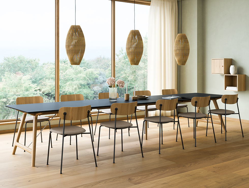 Andersen Furniture T7 Ausziehtisch 220 × 95 cm mit vier Einlegeplatten, schwarzer Laminatplatte und weiß geöltem Eichengestell, kombiniert mit Scope Stühlen mit Kvadrat Floyd Bezug.