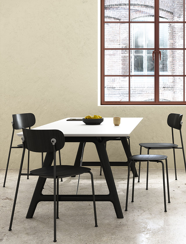 Der T7 Esstisch, entworfen von Ditlev Karsten, kombiniert neo-klassisches Design mit Funktionalität. Das Gestell besteht aus massiver Eiche, wählbar mit Ölfinish oder schwarzer Lackierung, während die Tischplatte in weißem oder schwarzem FENIX® Laminat erhältlich ist. Zwei Chromhalterungen unter dem Tisch sorgen für zusätzliche Stabilität.