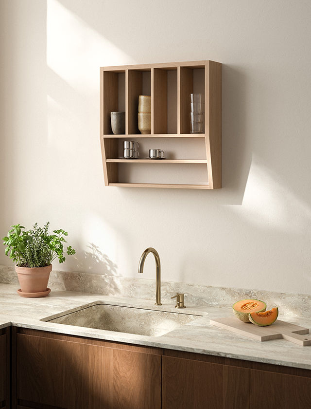 Andersen Furniture Reed Shelf Wandregal aus Eiche mit offenen Fächern und Keramik, montiert über einer Küchenzeile mit Naturstein-Arbeitsplatte.