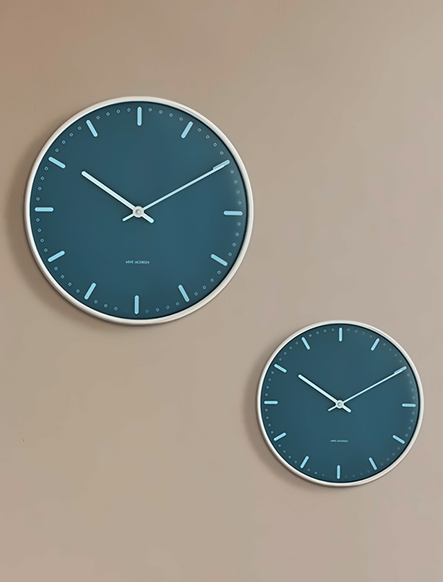 Zwei blaue City Hall Wanduhren in unterschiedlichen Größen als Wanddekoration im minimalistischen Interior.