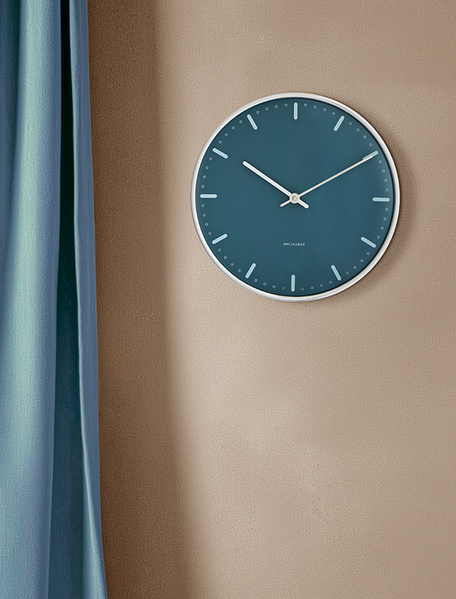 Arne Jacobsen City Hall Wanduhr in Blau mit weißem Rahmen – große Ausführung an beiger Wand.