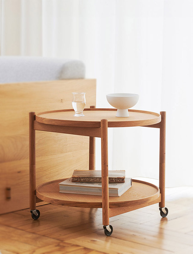 Brdr. Krüger Bølling Tray Table in 60cm Ø mit Holzgestell und Rollen als eleganter Serviertisch in wohnlicher Lounge-Atmosphäre.