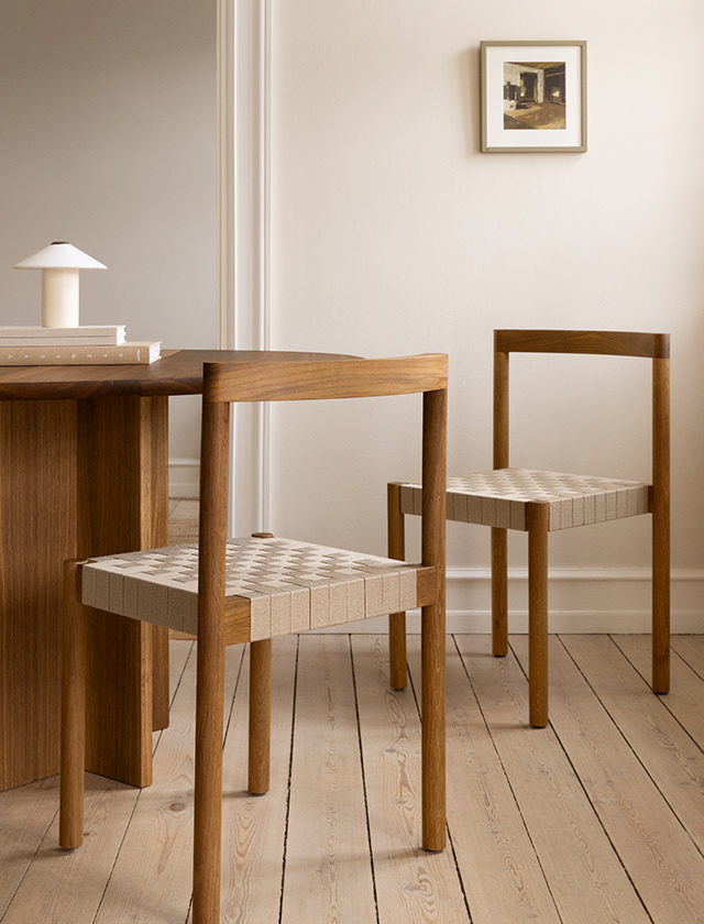 Das Bild zeigt einen FDB Møbler J81 Stuhl aus Eiche natur, der mit einer wasserlöslichen Lackierung versehen ist und das Nordic Swan Ecolabel trägt. Der Stuhl steht neben einem runden Holztisch in einem hellen, skandinavisch eingerichteten Esszimmer.