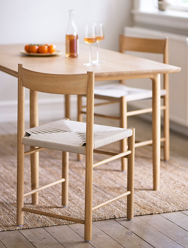 Der J52B Stuhl von FDB Møbler ist ein zeitloser Klassiker des skandinavischen Designs. Entworfen in den 1950er-Jahren, überzeugt er durch seine markante hohe Rückenlehne, die filigranen Sprossen und die bequemen Armlehnen. Gefertigt aus massiver Eiche natur und geölt, bringt er Wärme und Natürlichkeit in jeden Wohnraum.