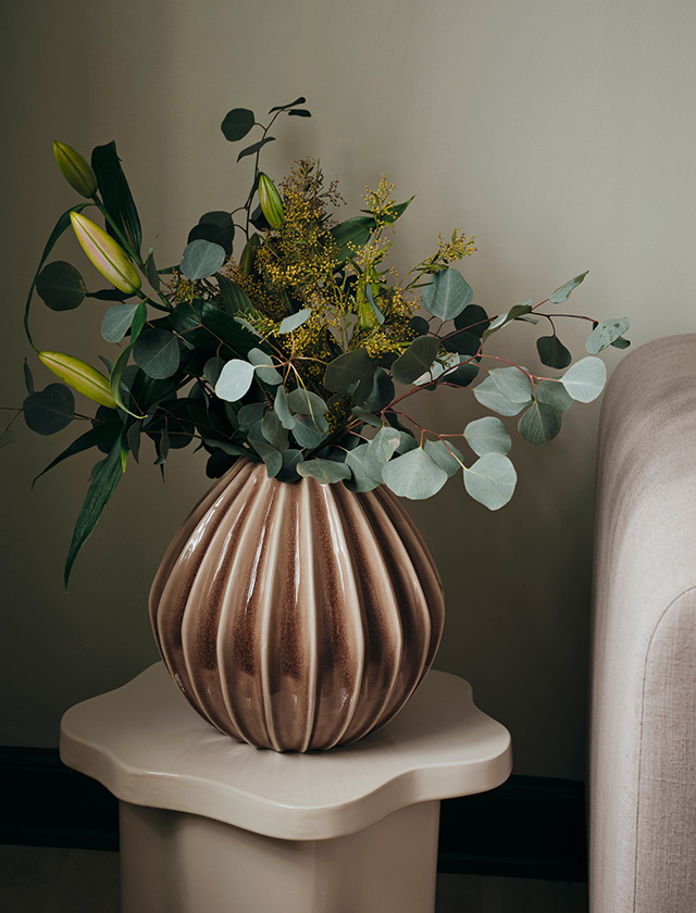 Broste Copenhagen Wide Vase in Fawn aus glasierter Keramik mit gerippter Oberfläche, dekoriert mit einem üppigen Blumenstrauß im Wohnzimmer.