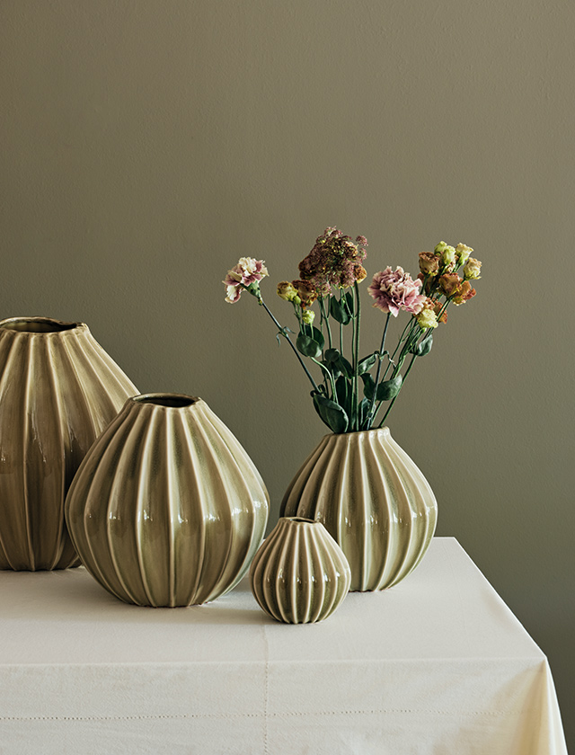 Broste Copenhagen Wide Vasen-Serie in Dry Sage Green aus Keramik – vier gerippte Vasen in unterschiedlichen Größen, dekorativ mit Blumen arrangiert.