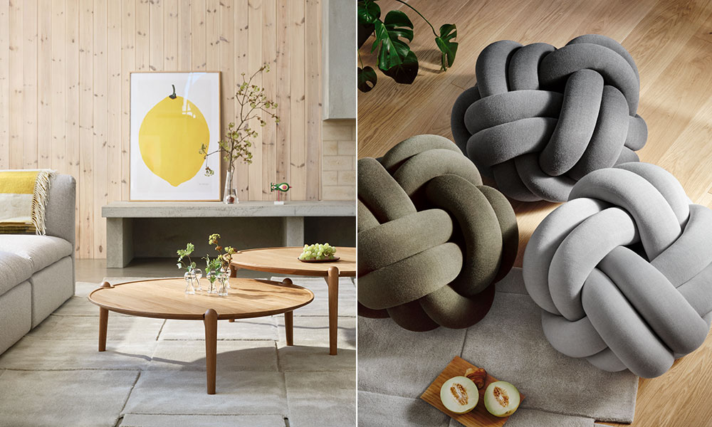 Linke Bildhälfte: Die Szene präsentiert ein minimalistisches skandinavisches Wohnzimmer mit klaren Linien und warmen Holztönen. Im Mittelpunkt stehen zwei runde „Aria“-Kaffeetische von Design House Stockholm, gefertigt aus hochwertigem Holz mit einer schlichten, eleganten Formensprache. Der Hintergrund zeigt eine helle Holzvertäfelung, dekoriert mit einem grafischen Zitronenposter, das frische Akzente setzt. Die Kaffeetische sind dezent mit Glasvasen und frischen Blumen dekoriert, was den natürlichen und gemütlichen Look unterstreicht.