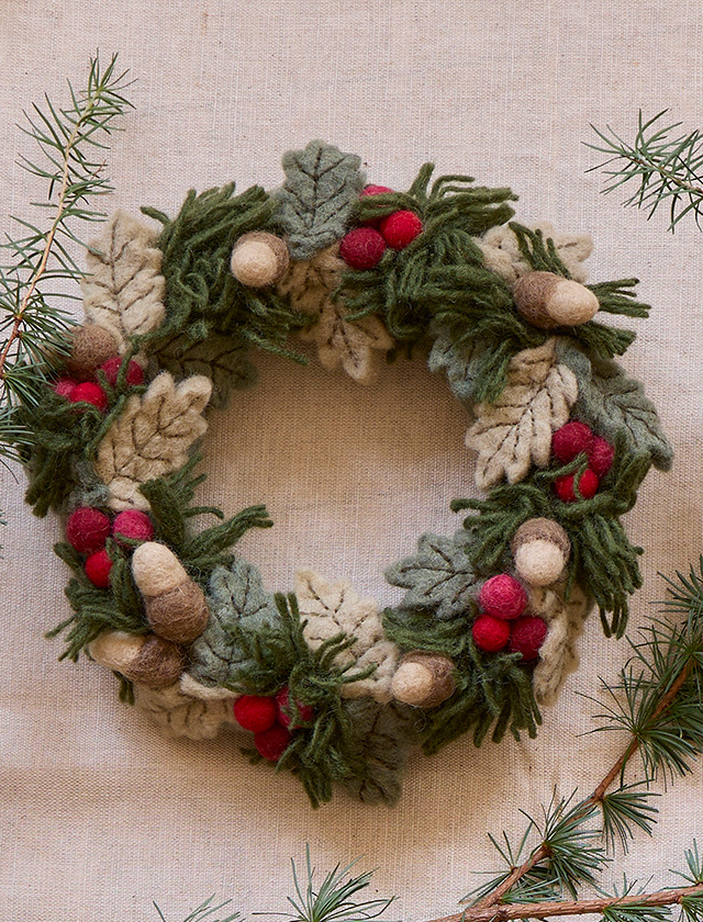 Handgefertigter Weihnachtskranz von Gry & Sif mit roten Beeren, weichen Filzblättern und Eicheln aus 100 % neuseeländischer Schurwolle als winterliche Dekoration für Tür oder Wand