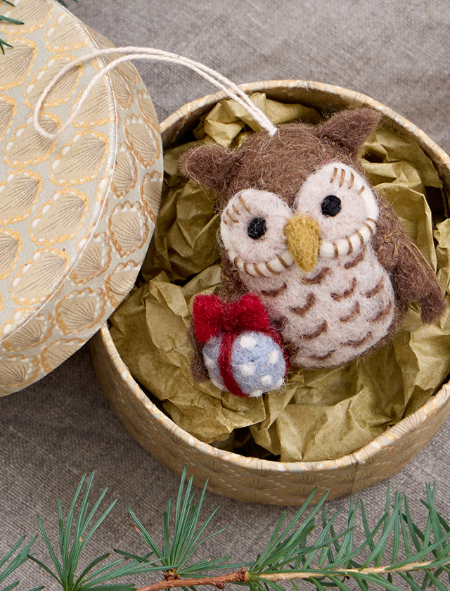 Handgefertigte Eule aus Filz von Gry & Sif mit kleinem Geschenk in Rot und Blau als winterliche Weihnachtsdekoration