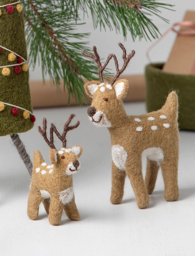 Zwei handgefertigte Rentiere aus Wollfilz von Gry & Sif in Braun mit weißer Zeichnung und Geweih als skandinavische Weihnachtsdekoration.