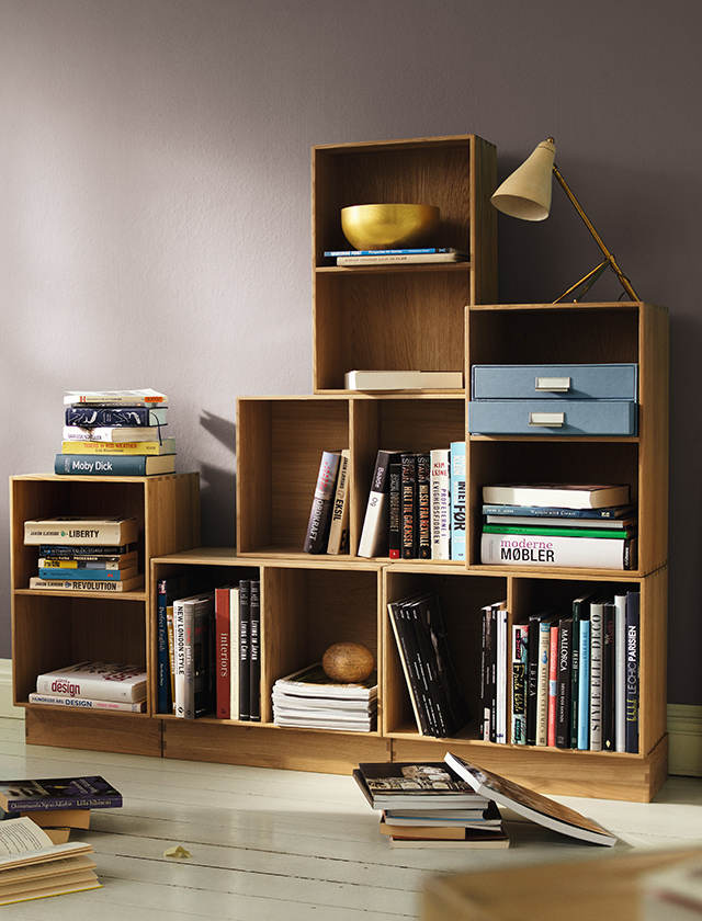 Das FDB Möbel B98 Bücherregal von Mogens Koch steht auf einem Sockel und ist mit Büchern, Zeitschriften und blauen Schubladen dekoriert. Es ist modular und verschiedenen Tifen erhältlich.