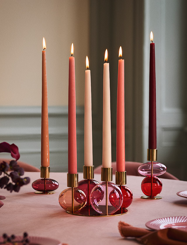 Holmegaard Bubble Kerzenhalter aus mundgeblasenem Glas mit Messing-Look in den Juwelentönen Bordeaux, Rubinrot, Pink-Saphir und Peachy-Koralle.