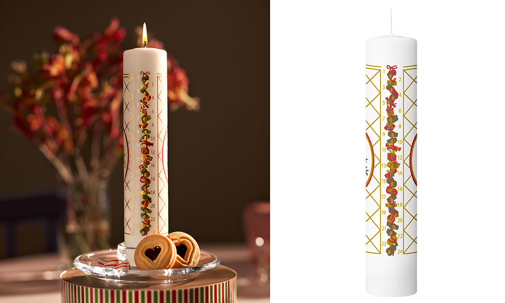 Die Holmegaard Christmas Kalenderkerze 2025, gestaltet von Jette Frølich, bringt skandinavische Weihnachtstradition stilvoll auf den Tisch. Auf der weißen, schlanken Kerze schlängelt sich eine festliche Reihe von Geschenkpaketen, Schleifen und Tannengrün von der Zahl 1 bis 24 – ein liebevoll gestalteter Countdown bis Heiligabend. Das filigrane Gittermuster in Gold umrahmt das Motiv und verleiht der Kerze eine elegante, fast nostalgische Ausstrahlung.