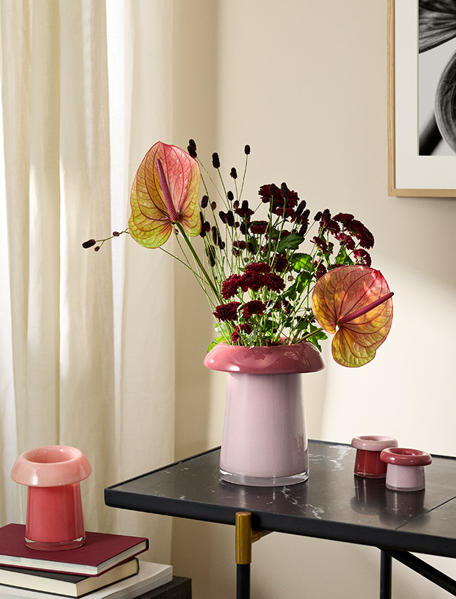Holmegaard Soma Vasen aus mundgeblasenem Glas: Vase H16,5 cm in Koralle/Pfirsich und Vase H22,5 cm in Rose/Terrakotta mit Blumenarrangement, daneben Soma Teelichthalter in Rose/Terrakotta.