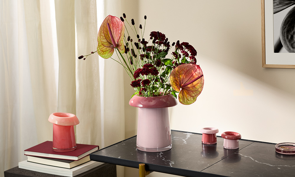 olmegaard Soma Vasen aus mundgeblasenem Glas: Vase H16,5 cm in Koralle/Pfirsich und Vase H22,5 cm in Rose/Terrakotta mit Blumenarrangement, daneben Soma Teelichthalter in Rose/Terrakotta.