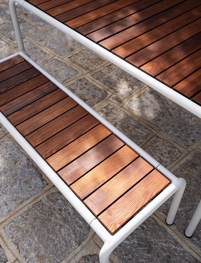 Avanti Gartentisch mit den Rahmen in Muted White und Lamellen aus Thermo Esche. Dazu passend die large Bänke in Muted White und Lamellen aus Thermo Esche