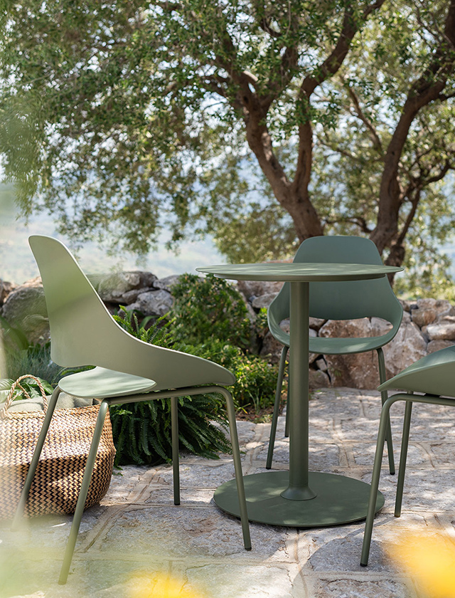 Eingebettet in mediterrane Natur lädt dieses stilvolle Outdoor-Arrangement der dänischen Designmarke HOUE zum Verweilen ein. Der kompakte PICO Bistrotisch mit runder Tischplatte und Rundfuß in elegantem Olivgrün bildet den Mittelpunkt. Gefertigt aus wetterfestem, pulverbeschichtetem Aluminium vereint er Funktionalität mit zeitloser Formensprache.