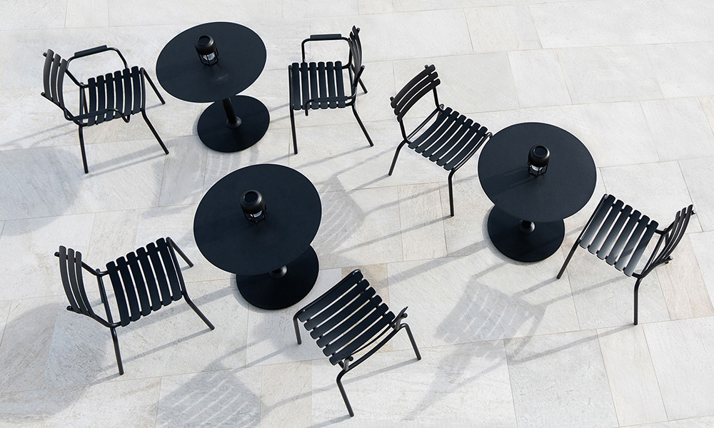HOUE Pico Gartentisch mit runder Aluminium-Tischplatte und stabilem Rundsockel in elegantem Schwarz kombiniert modernes, skandinavisches Design mit wetterfester Langlebigkeit. Gefertigt aus hochwertigem Aluminium und pulverbeschichtetem Stahl, eignet sich der Tisch ideal für den Einsatz auf der Terrasse, im Garten, auf dem Balkon oder in der Gastronomie. Ergänzt wird das Set durch die formschönen HOUE ALUA Aluminium-Gartenstühle, die mit ihrem leichten, rostfreien Rahmen, ergonomischer Form und klarer Linienführung perfekt auf den Tisch abgestimmt sind. Die Kombination aus langlebigen Materialien, minimalistischer Ästhetik und hohem Sitzkomfort macht dieses Ensemble zur idealen Wahl für stilvolle Outdoor-Bereiche.