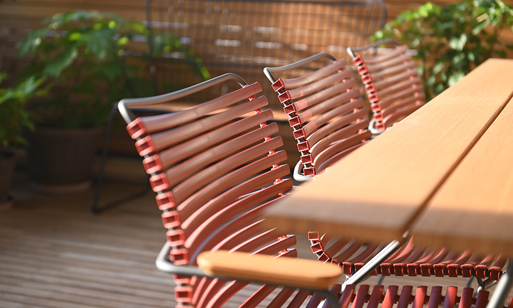 Gartenmöbel auf dem Balkon im elbdal Laden in Radebeul. Das Foto zeigt Click-Gartenstühle und einen Sketch-Gartentisch von HOUE. Im Hintergrund ist eine Gartenbank aus der Paon-Serie zu sehen. Außerdem Pflanzgefäße von Bergs Potter.