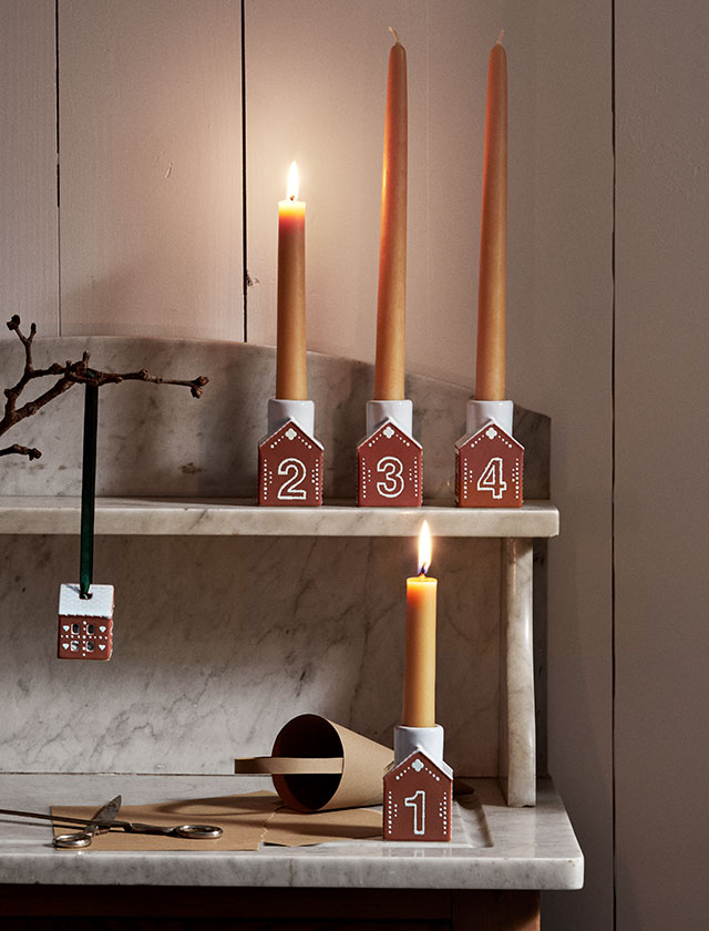 Ein geschmackvoller Weihnachtsklassiker aus handgefertigter Keramik, geformt durch Tradition: Der Kähler Gingerbread Adventskerzenhalter besteht aus vier kleinen Mini-Lebkuchenhäusern, die jeweils mit den handgezeichneten Zahlen 1 bis 4 verziert sind. Jedes Keramikhaus ist 7,5 cm hoch, detailreich dekoriert und erinnert mit seiner weißen Glasur und den filigranen Mustern an frisch gebackene Lebkuchenhäuser.