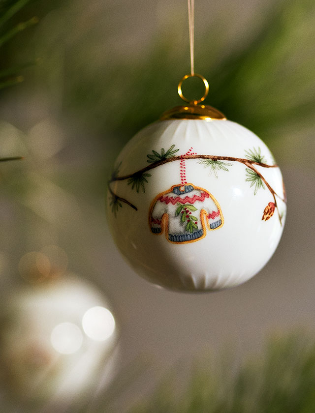 Ein Hauch von Nostalgie, eingefangen in feinstem Porzellan: Die Hammershøi Weihnachtsbaumkugel 2025 von Kähler Design verbindet traditionelles skandinavisches Weihnachtsgefühl mit zeitloser Eleganz. Das filigrane Dekor zeigt einen liebevoll gestalteten Strickpullover, der wie frisch von der winterlichen Leine genommen wirkt – ein Symbol für Wärme, Geborgenheit und die kleinen Freuden der Adventszeit.