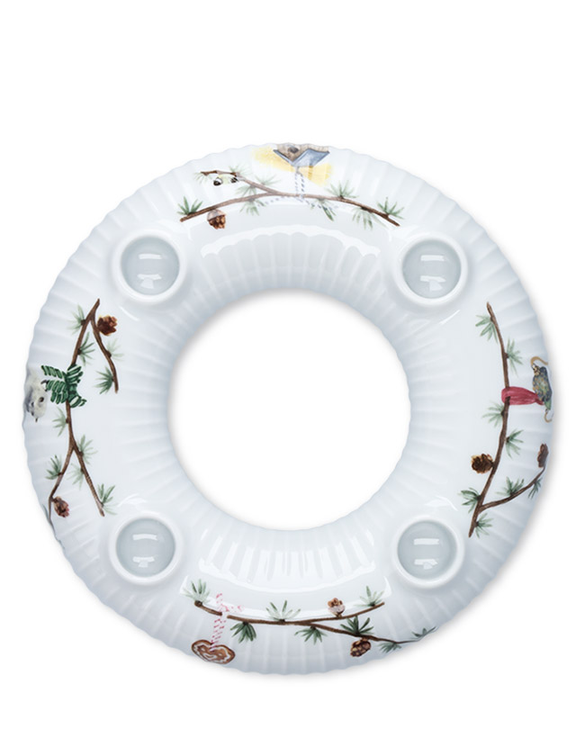 Kähler Design Hammershøi Jul Adventskranz aus weißem Porzellan, dekoriert mit vier roten Kerzen, Tannenzweigen und traditionellen Weihnachtsmotiven für eine stimmungsvolle Adventszeit.