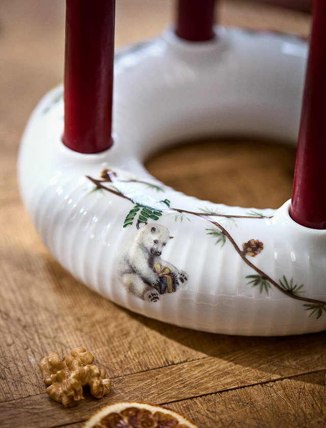 Kähler Design Hammershøi Jul Adventskranz aus weißem Porzellan mit vier roten Kerzen, Tannenzweigen und liebevoll gestalteten Weihnachtsmotiven – skandinavischer Kerzenhalter und festliche Weihnachtsdekoration für die Adventszeit.