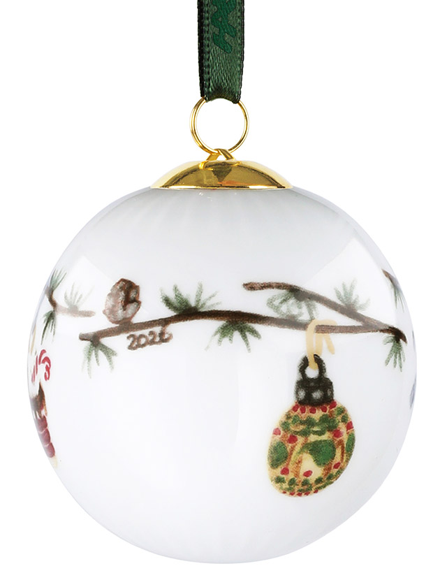 Kähler Design Hammershøi Jul Christbaumkugel 2026 aus weißem Porzellan mit Tannenzweigen, farbigem Christbaumkugelmotiv, goldfarbener Aufhängung und grünem Band.