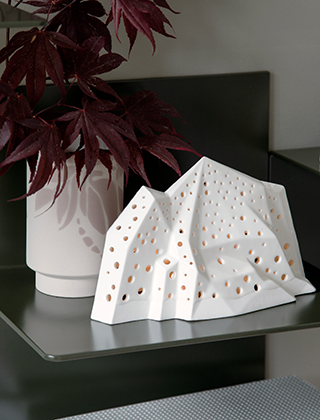 Nobili Mountain Stimmungslicht - Teelichthalter in Schneeweiß von Kähler Design und Kabell-Vase in Staubrosa auf einem Wandregal aus Metall von Word.dk