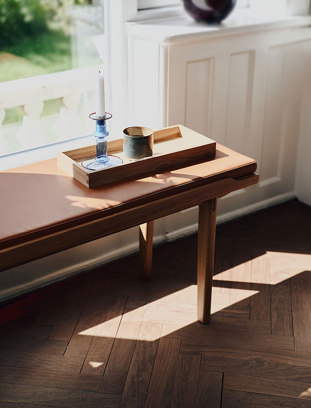 Die KA60 Sitzbank mit edlem Leder-Sitzkissen, die Komfort und Eleganz in einem zeitlosen skandinavischen Stil bietet.