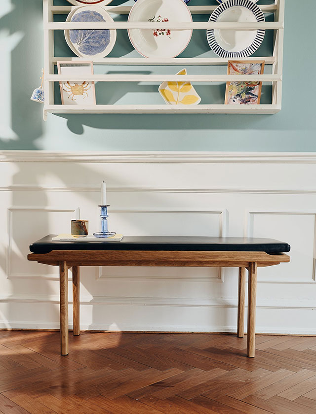 Die KA60 Sitzbank aus geölter Eiche mit edlem Leder-Sitzkissen in Schwarz als Ablage für schöne Dinge.