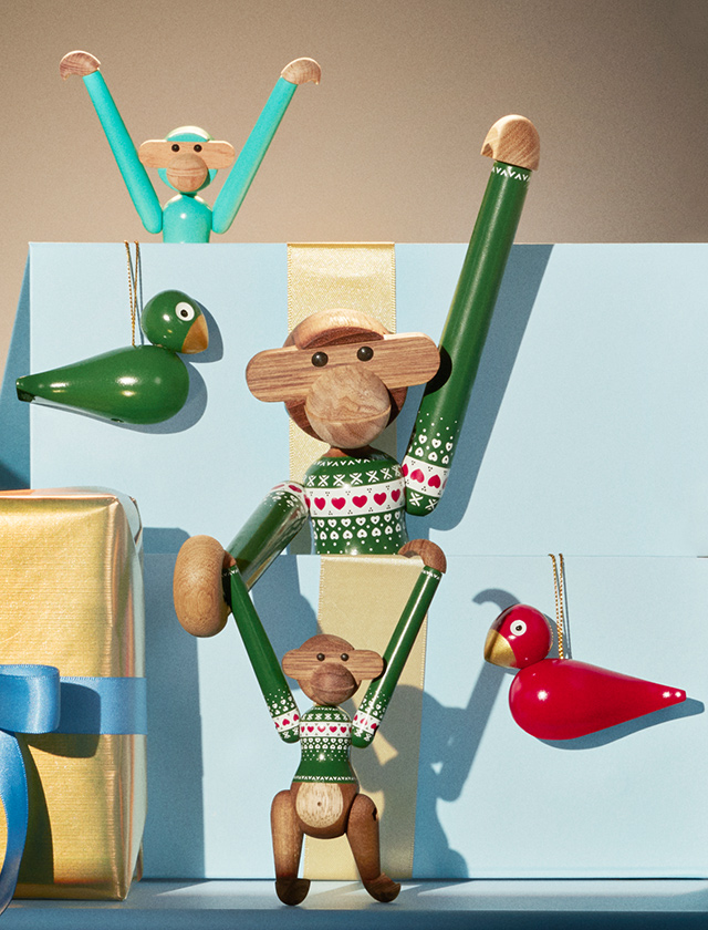 Kay Bojesen Affe Christmas Jumper Green in den Größen 18,5 cm und 9,5 cm mit grünem Weihnachtspullover, roten und weißen Herzmotiven und weiteren Kay Bojesen Holzfiguren in einer festlichen skandinavischen Weihnachtsszene.