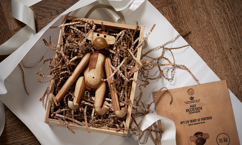 Der Jubiläumsaffe markiert eine besondere Edition des ikonischen Holzaffen, gefertigt aus Restholz. Dieses exklusive Modell trägt einen 70-Jahre-Jubiläumsstempel auf seiner Pfote und wird in einer eigens gestalteten Holzbox präsentiert. Es wird nur im Jahr 2021 in limitierter Auflage produziert. Dieser Jubiläumsaffe ist nicht nur eine Hommage, sondern auch eine Aussage. Er feiert die 70 Jahre seit Kay Bojesen die ersten fröhlichen Konturen dieses kultigen Affen schnitzte und betont zugleich die Verantwortung und das Handwerk, das in sein Design einfließt.