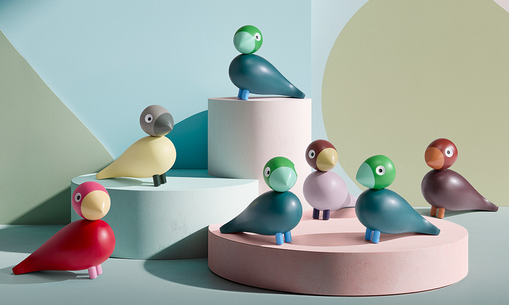 Farbenfrohe Kay Bojesen Year Birds Family als Gruppenmotiv: die Jahresvögel Poppy (2022), Jackie (2023), Flora (2024), Bella (2025) und Birk (2026) in pastelligen Farben. Stilvolles Stillleben mit den ikonischen Holzvogel-Figuren im skandinavischen Design – ideal für Sammler, Dekoration und Geschenkideen.