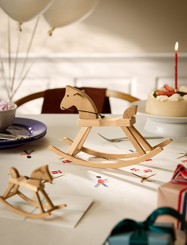 Kay Bojesen Mini- und Kleines Schaukelpferd aus FSC®-zertifiziertem Buchenholz als dänische Designklassiker auf einem festlich gedeckten Geburtstagstisch.