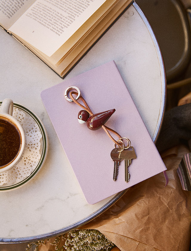Kay Bojesen Singvogel Schlüsselanhänger in Beige aus Holz, dekorativ an einer Gürtelschlaufe an der Hose befestigt – skandinavisches Design von Kay Bojesen.