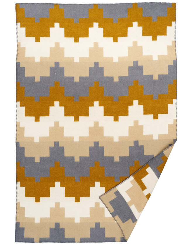 Klippan Cancun Wolldecke mit grafischem Muster in Blau, Senfgelb, Beige und Weiß.