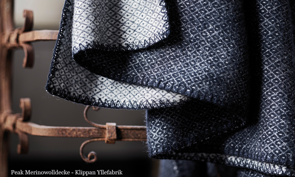 Klippan Peak Premium-Wolldecke aus Merinowolle und Lammwolle in Dark Demin von Klippan Yllefabrik. Peak Wolldecken werden aus 60% gebürsteter Merinowolle und aus 40% gebürsteter Lammwolle gefertigt. Die Peak Decke ist in den Farben Grey, Dark Demin, Petroleum, Cactus und Naturel Beige verfügbar. Ihre Größe beträgt 130 cm x 180 cm.