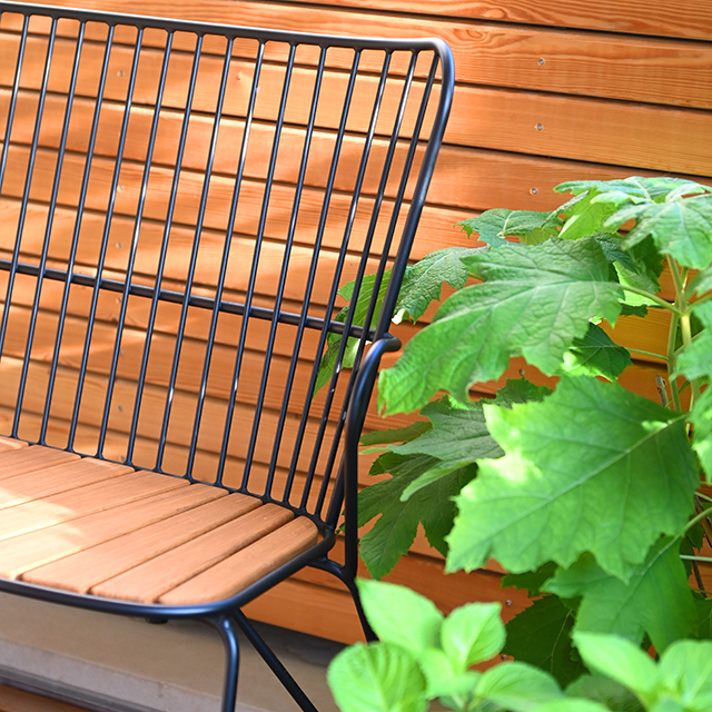 Schwarze Paon-Gartenbank von HOUE mit Sitzfläche aus Bambus auf der Gartenmöbel-Terrasse im elbdal Ladengeschäft in Radebeul.