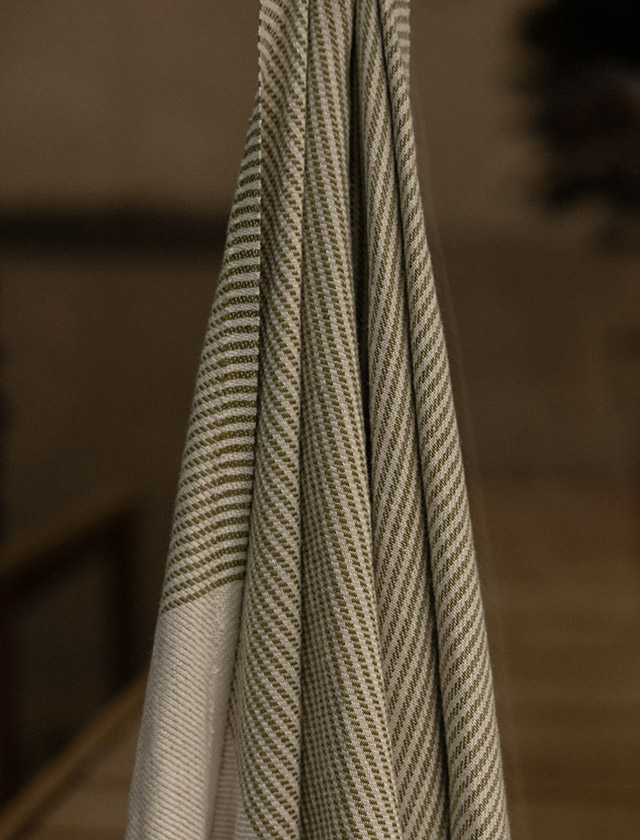 KAISLA Leinen-Badetuch, auch als Saunatuch und Saunaunterlage nutzbar – Outdoor am Wasser und Indoor auf der Saunabank im Wellnessbereich.