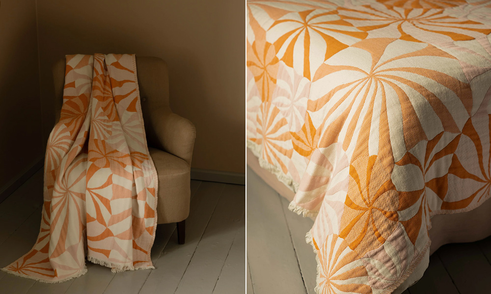 LOISTE Decke von Lapuan Kankurit aus Bio-Baumwolle und Merinowolle mit grafischem Blütenmuster in Orange- und Rosétönen, Design Rita Vaali.