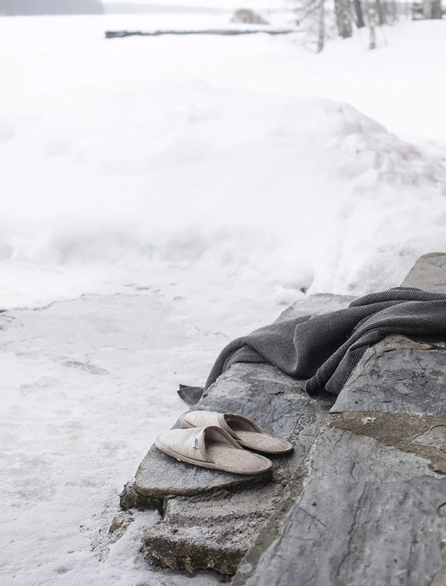 Onni Saunaschuhe aus Leinen von Lapuan Kankurit – beige Slipper vor Holzsauna im Schnee.