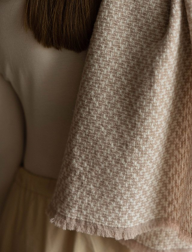 Der Salla Schal von Lapuan Kankurit aus Finnland zeigt ein feines Hahnentritt-Muster in Beige-White. Gefertigt aus weicher Merinowolle, wirkt der Schal angenehm wärmend, leicht und hochwertig. Das Bild zeigt den Schal in Nahaufnahme – ideal, um die natürliche Struktur, die warme Farbgebung und die nordische Ausstrahlung des Merino-Wollschals zu zeigen.