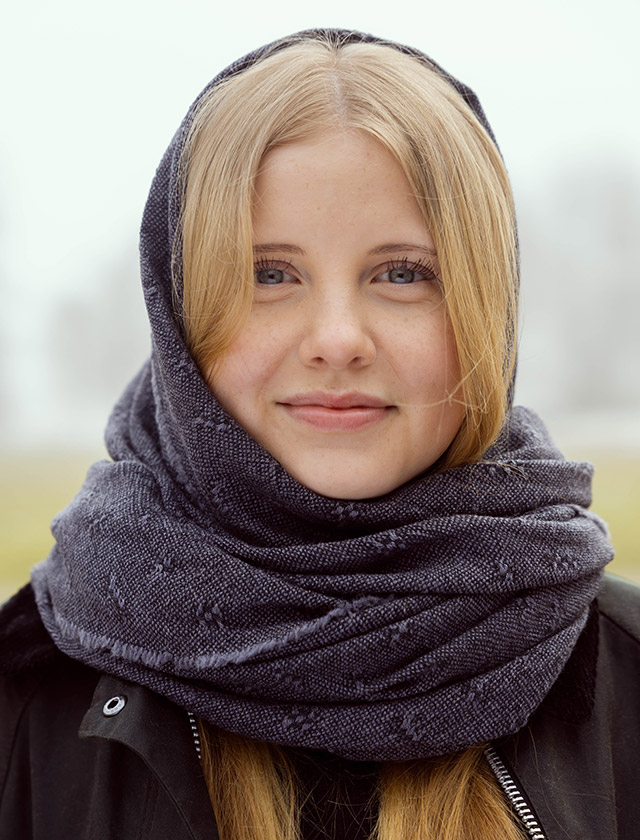 Tuula Schal von Lapuan Kankurit aus weicher Merinowolle, entworfen von Elina Helenius, in dunklen Farbton Black Grey getragen im natürlichen Outdoor-Ambiente.