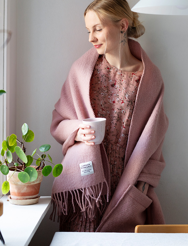 Der Uni Pocket Shawl in Pale Rose von Lapuan Kankurit geht über ein simples Accessoire hinaus. Er vereint stilvolles Design mit praktischem Nutzen, schenkt an kühlen Tagen Wärme und hat Taschen, die ideal für Handy, Schlüssel und Portemonnaie sind. Er verleiht jedem Outfit das gewisse Etwas und ist zugleich der perfekte Sofa-Gefährte, in dem man Fernbedienung oder Snacks verstauen kann. Wahrlich ein Highlight in der Welt der Accessoires!